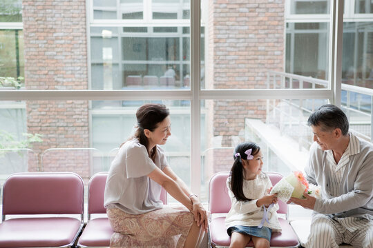 入院中の祖父にお見舞いの花を渡す女の子