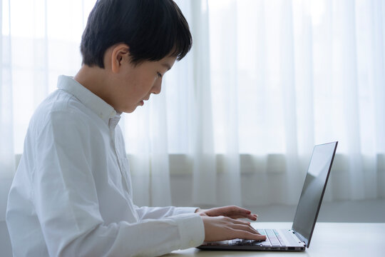 ノートパソコンを操作する男子学生