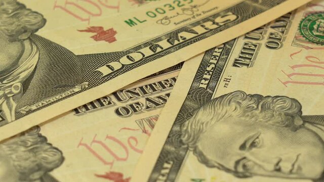 Closeup view video of many american dollars appearing quickly on white table background. Counting several 10 dollar paper banknotes.