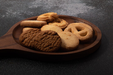 Cookies in a wooden plate on a black background