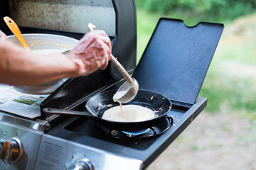 Making crêpes on gas burner with cast iron pan