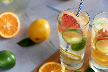 Health care, fitness, healthy nutrition diet concept. Fresh cool homemade citrus infused detox water with grapefruit, orange, lemon and lime and ice in a jug and glasses for spring summer days.