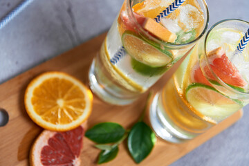 Health care, fitness, healthy nutrition diet concept. Fresh cool homemade citrus infused detox water with grapefruit, orange, lemon and lime and ice in a jug and glasses for spring summer days.