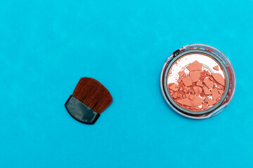 Broken blush and brush isolated on blue background