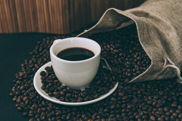 Retro fabric bag with coffee beans and a cup on the table.