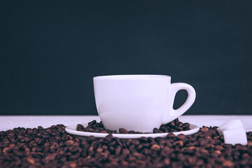 Cup for a drink with sugar on the background of coffee beans.