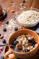 breakfasr with oatmeal porridge with blueberries, fruits,  almonds and coconut milk. Healthy and tasty vegan breakfast. top view.