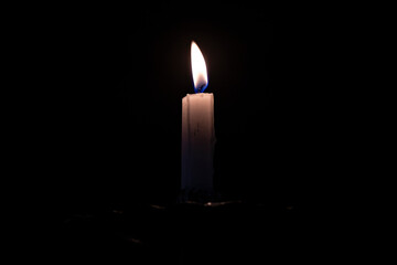 Closeup of a mystical candle flame on an extremely dark background. With space for text.