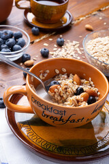 breakfasr with oatmeal porridge with blueberries, fruits,  almonds and coconut milk. Healthy and tasty vegan breakfast. top view.