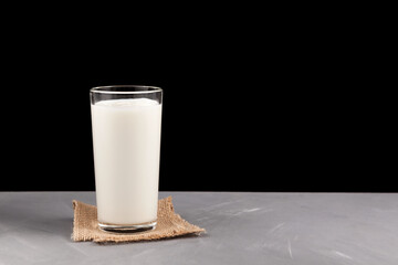 Ayran or kefir in a glass on a dark background. Fermented milk ayran. Milk diet for weight loss. Selective focus. Place for text