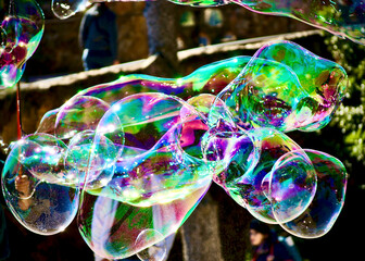 multicoloured big soap bubbles street artist in park Guell Barcellona