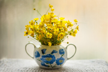 Yellow small flowers in a beautiful vase. Bouquet of buttercups