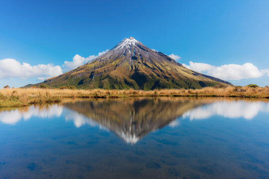 View of the Taranaki volcano in New Zealand northern island reflecting in a mountain pond on a sunny day
