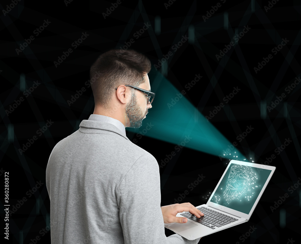 Poster facial recognition system. man using laptop on color background