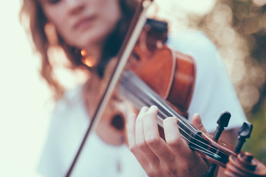 Midsection of young woman playing violin