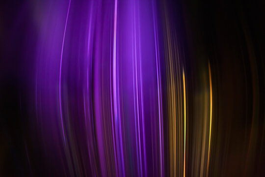 Full frame abstract image of purple and golden light trails