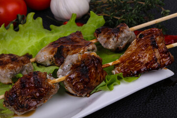 Pork kebab skewers in the plate with salad leaves and tomatoes