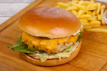 Homemade burger with fish, cheese and salad leaves