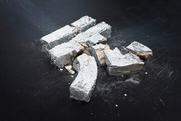 High angle view of broken concrete New Taiwan dollar symbol on table