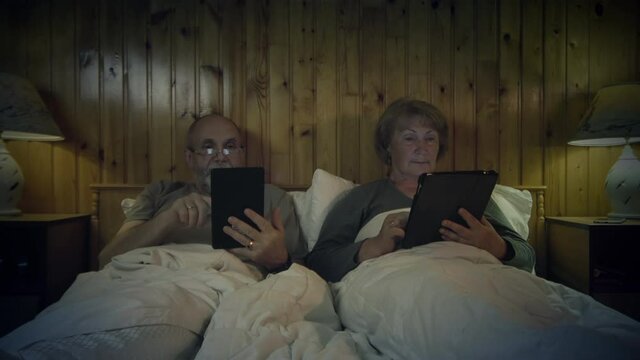 Senior Couple Reading In Bed
