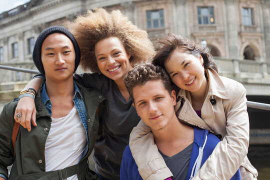 Low angle portrait of smiling young multi-ethnic friends against Bode Museum, Berlin, Germany