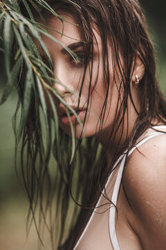 Portrait of young woman with wet hair by plant