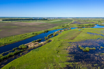 Scenic aerial view of a river and green fields in a countryside