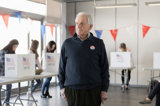 Portrait of senior man standing at American polling place