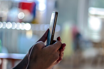Close-up image of young girl chatting with family at social networks, sunlight on the background. Woman typing  message on smart phone. Hands of a woman holding a mobile phone.