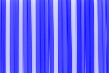 A solid background of many plastic colored straws arranged in row