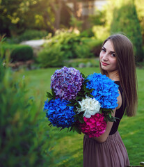 florist girl prepares a bouquet of hydrangeas in a beautiful garden