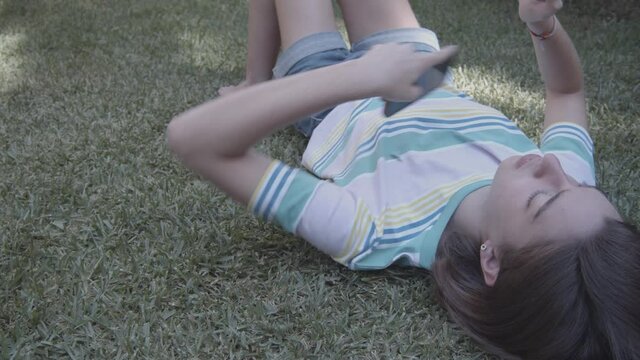 A teenage girl throwing her cell phone into the wild, digital detox, concept of getting rid of technologies after quarantine.