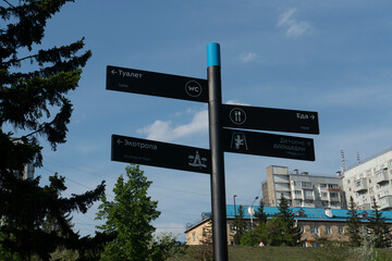 Fototapeta premium Gray post direction indicator in the park. Indicate Toilet, Playground, Ecotropic, Food.