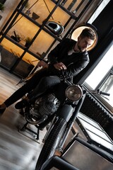 Stylish young man in leather jacket sitting on motorbike.