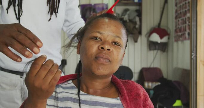 African woman having her hair styled