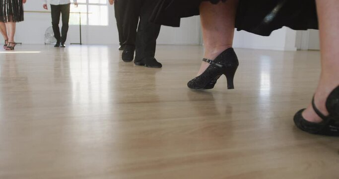 mixed race male dance teacher taking a ballroom dancing class at a dance studio