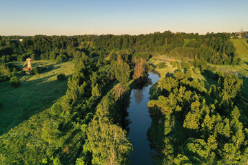 panoramic view of green meadows in the morning haze at sunrise shot from a drone at dawn