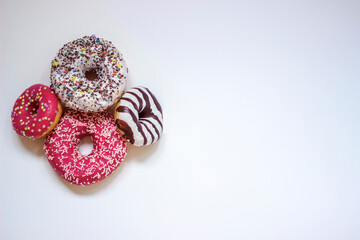 Colorful donuts on white background. Group of glazed donuts isolated on white background. Top view of beautiful donuts, space for text.