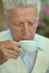 Portrait of cute senior man drinking coffee