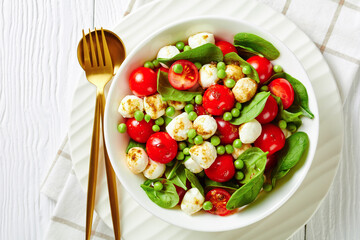 A plate with peas, mozzarella, and spinach salad