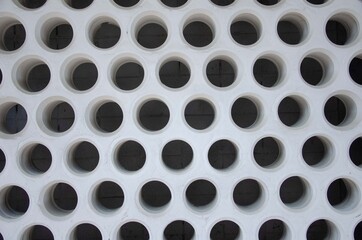 Concrete wall with holes, many geometric holes in the wall background
