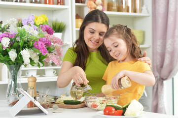 Cute little girl with her mother cooking together