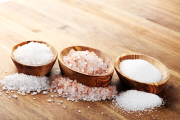 Sea salt and himalayan on spoon. Crystals of salt on background