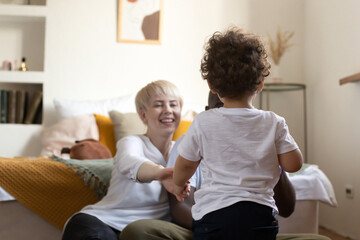 Fototapeta premium small child walks with his back to his happy parents