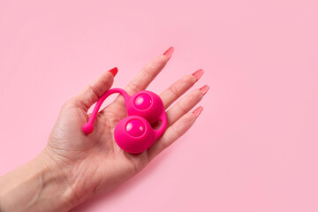 Adult toy, Dildo in hand on a pink background