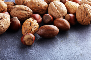 mixed nuts on grey background. Healthy food and snack. Walnut, pecan, almonds and hazelnuts