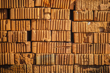 Red brick. Texture. Pallet of paving slab closeup on a construction site in sunny day. Paving slabs in the packaging at the construction site. Brick. Close-up.