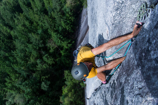 Man placing pro while climbing wide crack granite on Squamish Chief