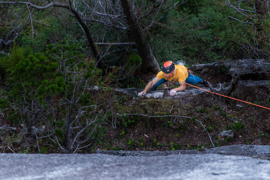 Man rock climbing in the woods to ledge top rope Squamish Chief