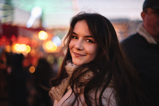 Portrait of happy teenage girl walking in Christmas market in city
